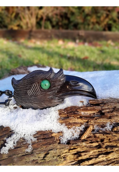 Hand-carved Viking black raven amulet with green eye.